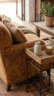 Cozy living room with patterned sofa, side table, and potted plant.