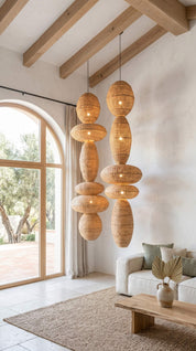Modern living room with hanging wicker lampshades, white sofa, and large window.