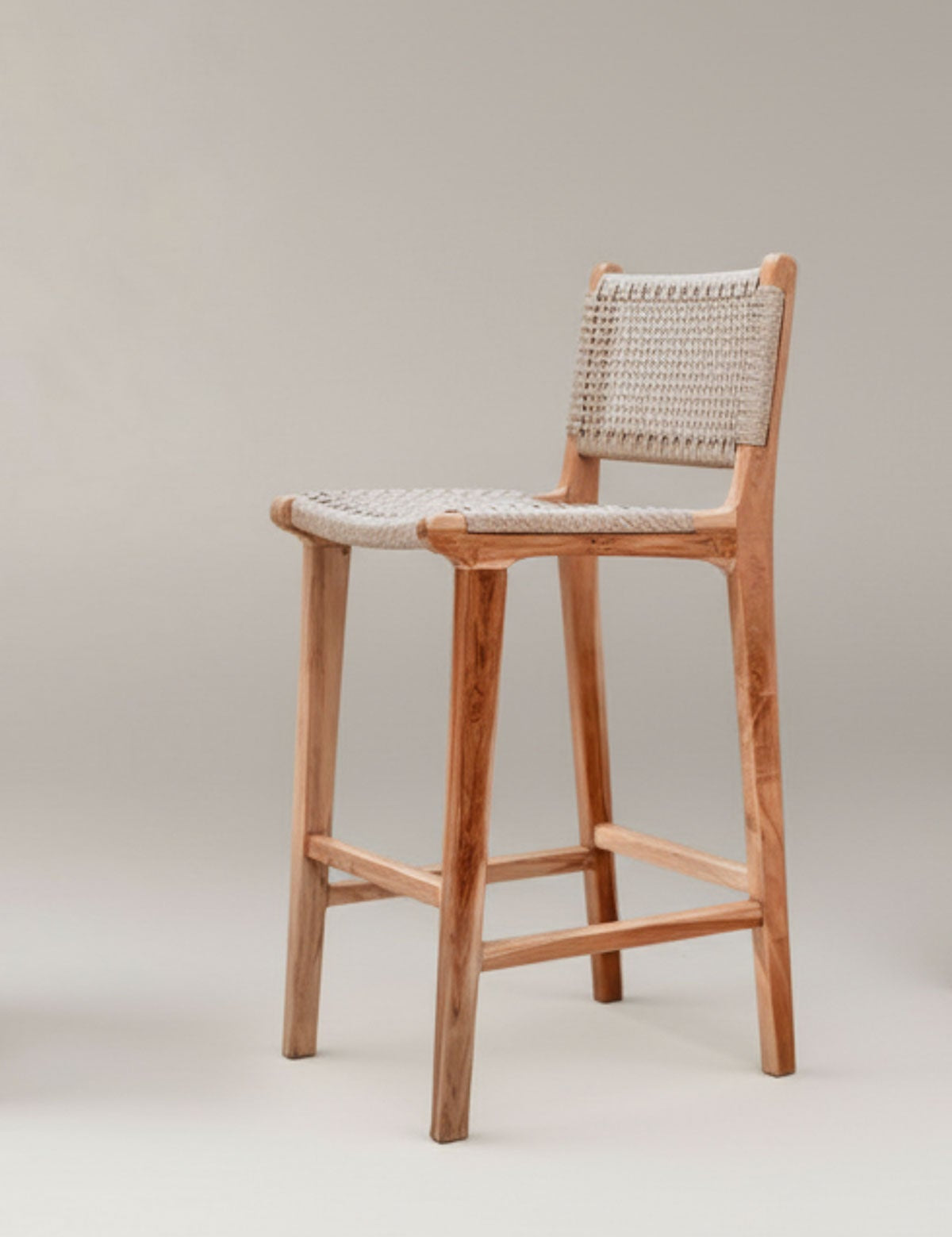Wooden bar stool with woven backrest on a plain background
