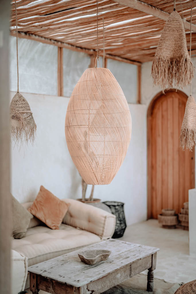 Woven pendant lights hanging in a living room with a couch and coffee table.