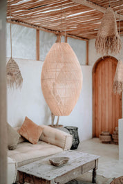 Woven pendant lights hanging in a living room with a couch and coffee table.