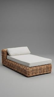 Wicker outdoor lounge chair with white cushions on a gray background