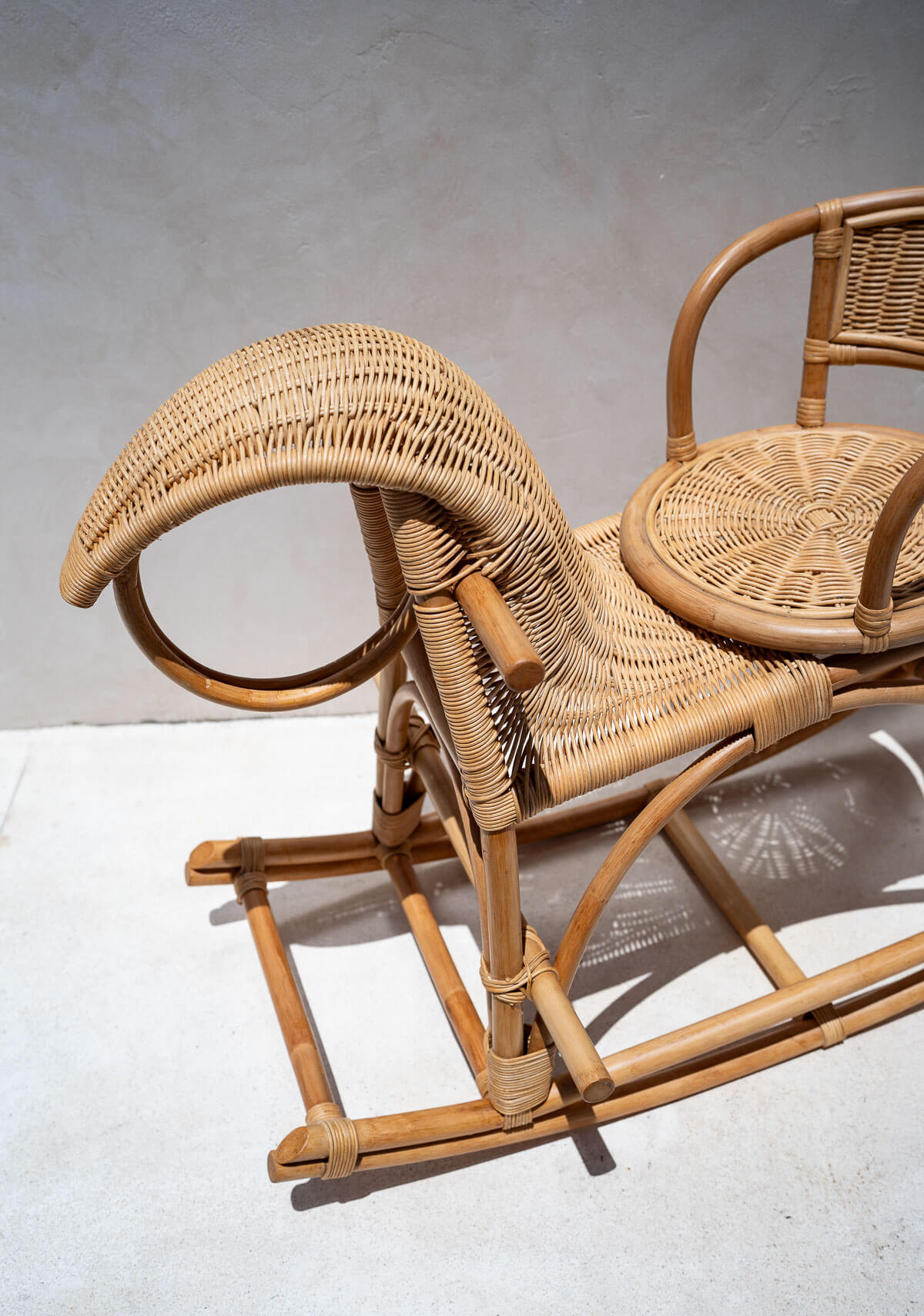 Wicker chair with a curved backrest on a light background