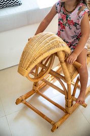 Child sitting on a wicker chair indoors