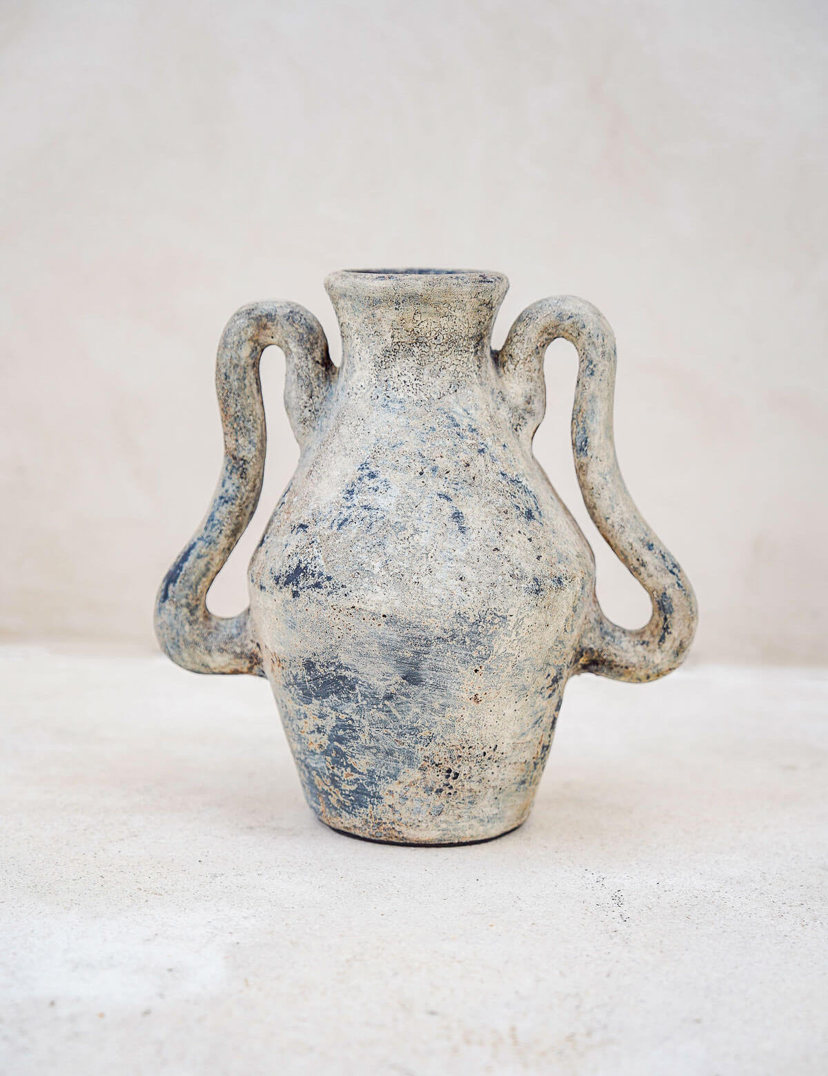 Ceramic vase with two handles on a light background