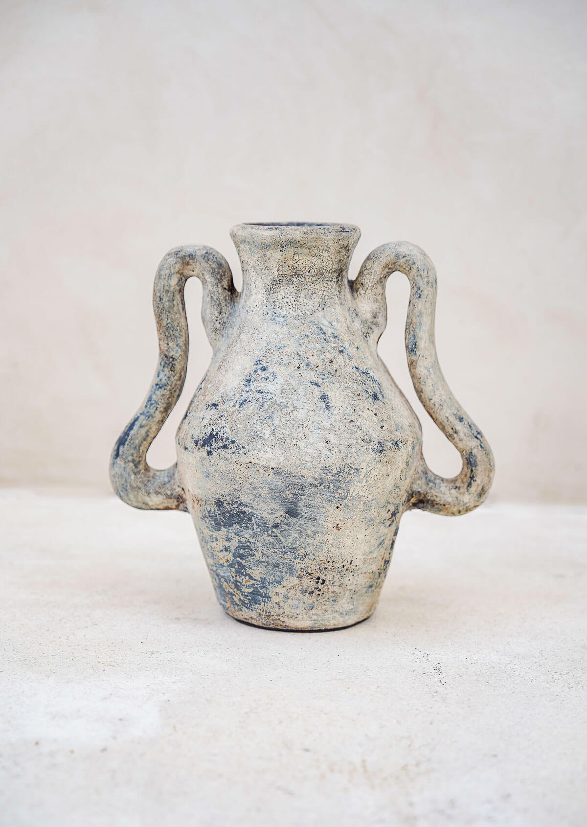 Ceramic vase with two handles on a light background