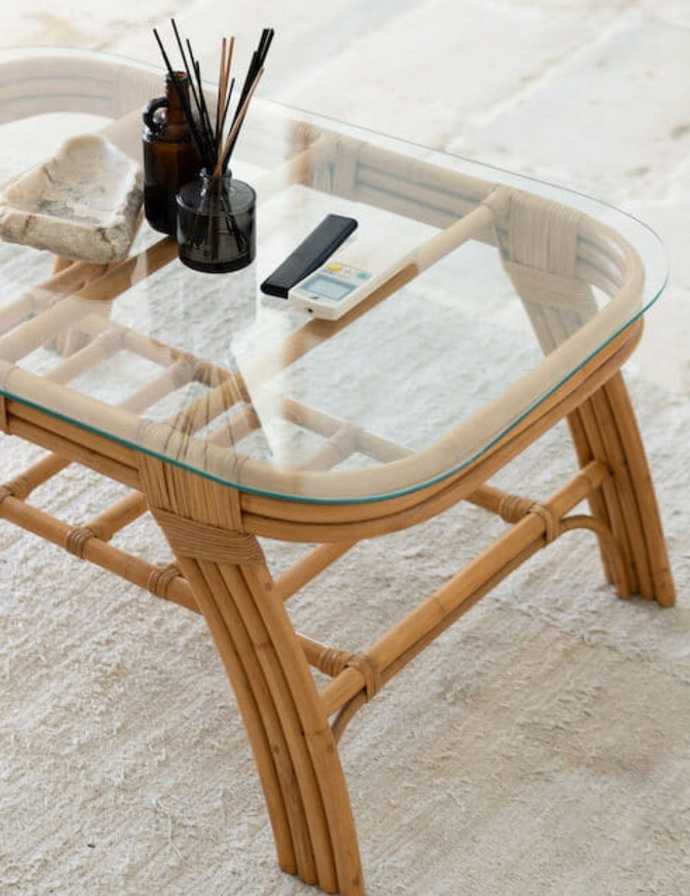 Handcrafted Sali rattan table with thick glass top and central shelf, featuring opalescent natural tones and elegant, unique design.