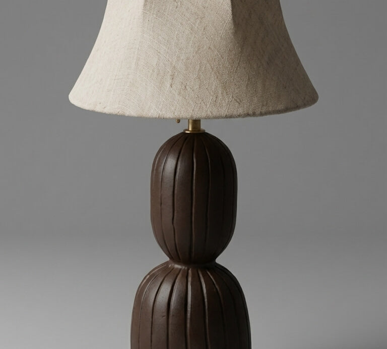 Table lamp with a brown base and beige shade on a gray background