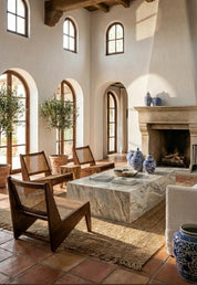 Living room with wooden chairs, marble coffee table, and decorative vases.