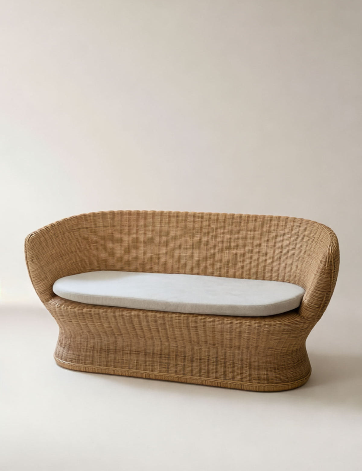 Wicker chair with a white cushion on a plain background