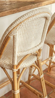 Close-up of a wicker chair with a wooden table in the background.
