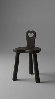 Wooden chair with a heart-shaped backrest on a gray background