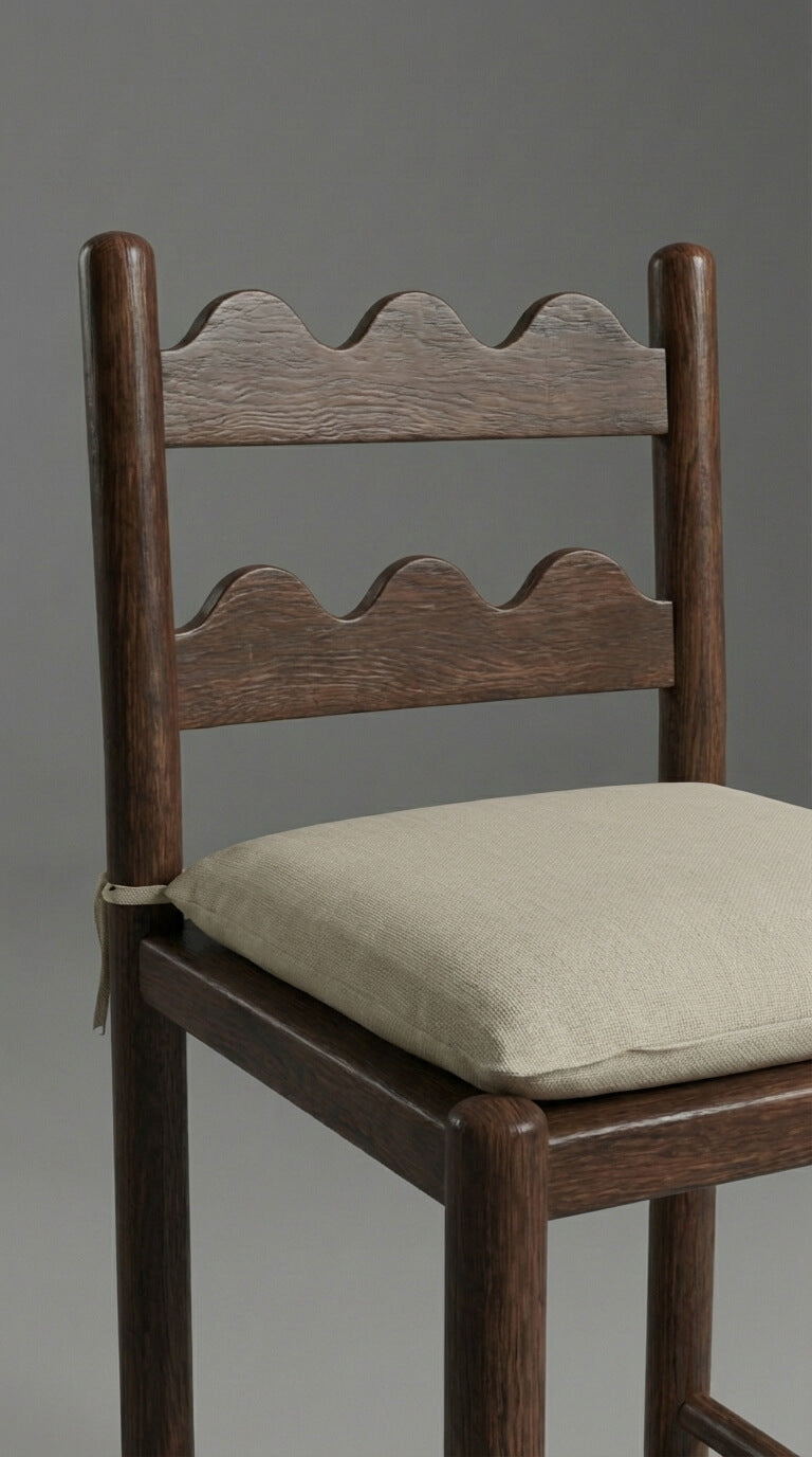 Wooden chair with a beige cushion on a gray background