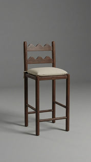 Wooden bar stool with a cushioned seat on a gray background