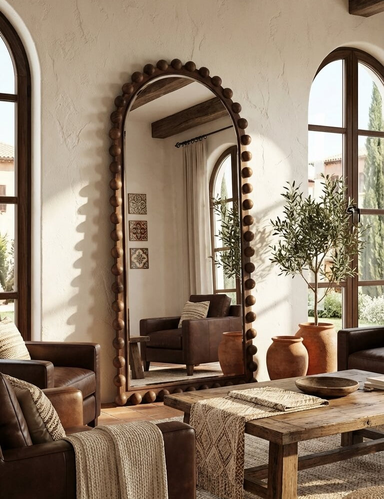 Living room with a large decorative mirror, wooden furniture, and plants.