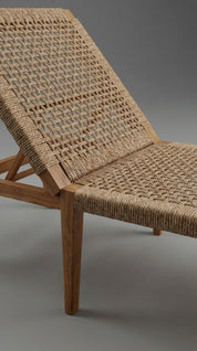Woven chair with wooden frame on a gray background