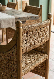 Sculptural teak wood and seagrass armchair in modern room
