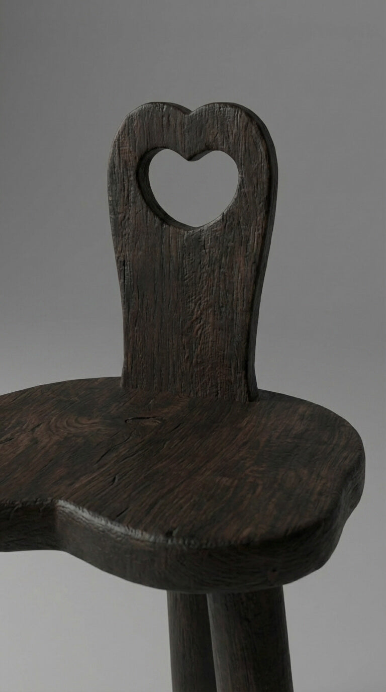 Wooden chair with a heart-shaped backrest on a gray background