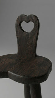 Wooden chair with a heart-shaped backrest on a gray background