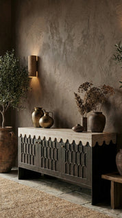 Wooden sideboard with decorative vases against a textured wall.