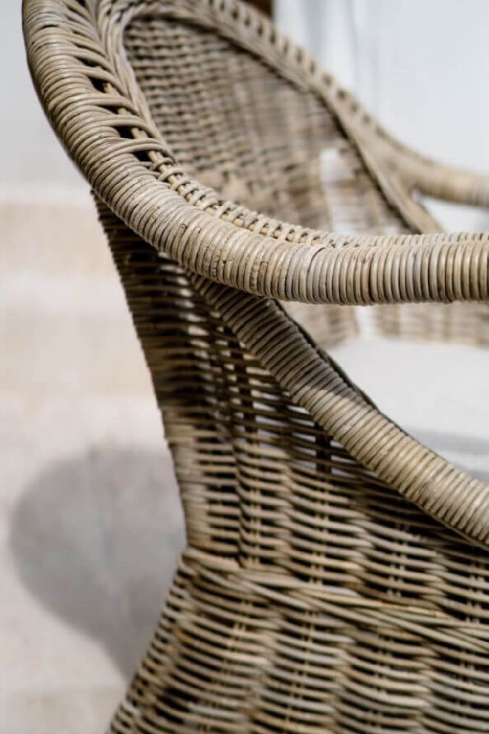 Handcrafted Tyo rattan armchair with curved armrests and woven headrest in natural autumn tones