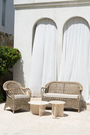 Handcrafted Tyo rattan armchair with curved armrests and woven headrest in natural autumn tones