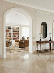 Luxurious interior with marble flooring, bookshelf, and sofa.