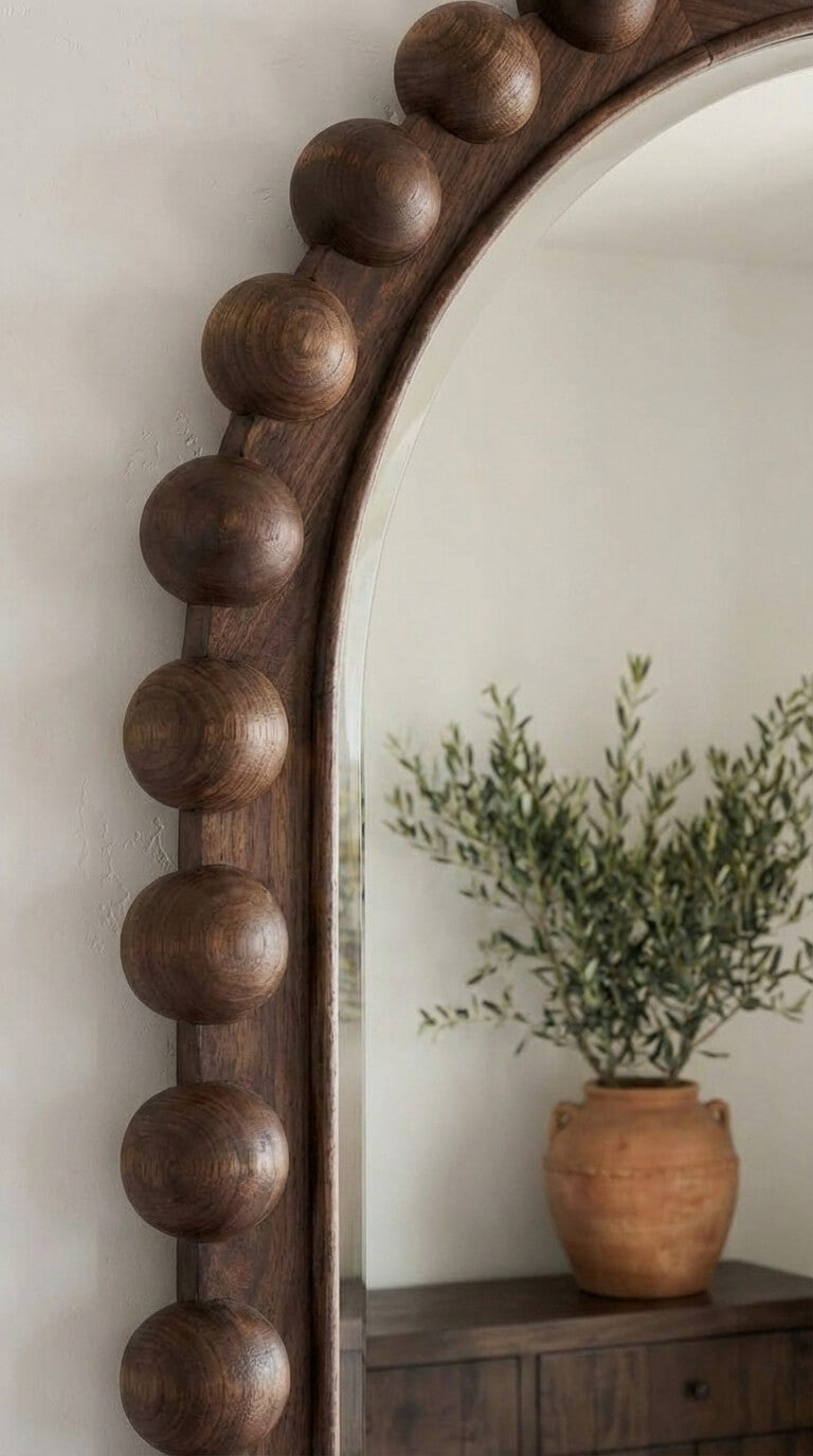Wooden beaded mirror with a plant on a shelf in the background