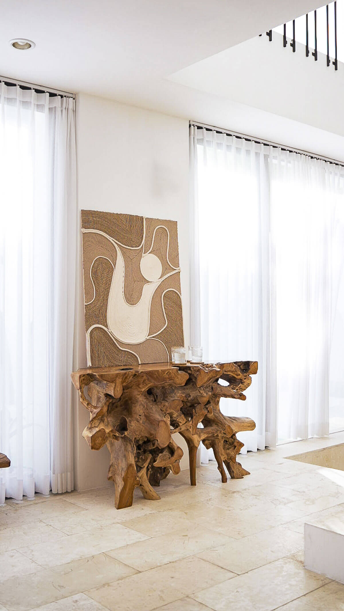 Modern interior with a wooden table and abstract art in a well-lit room.