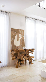 Modern interior with a wooden table and abstract art in a well-lit room.