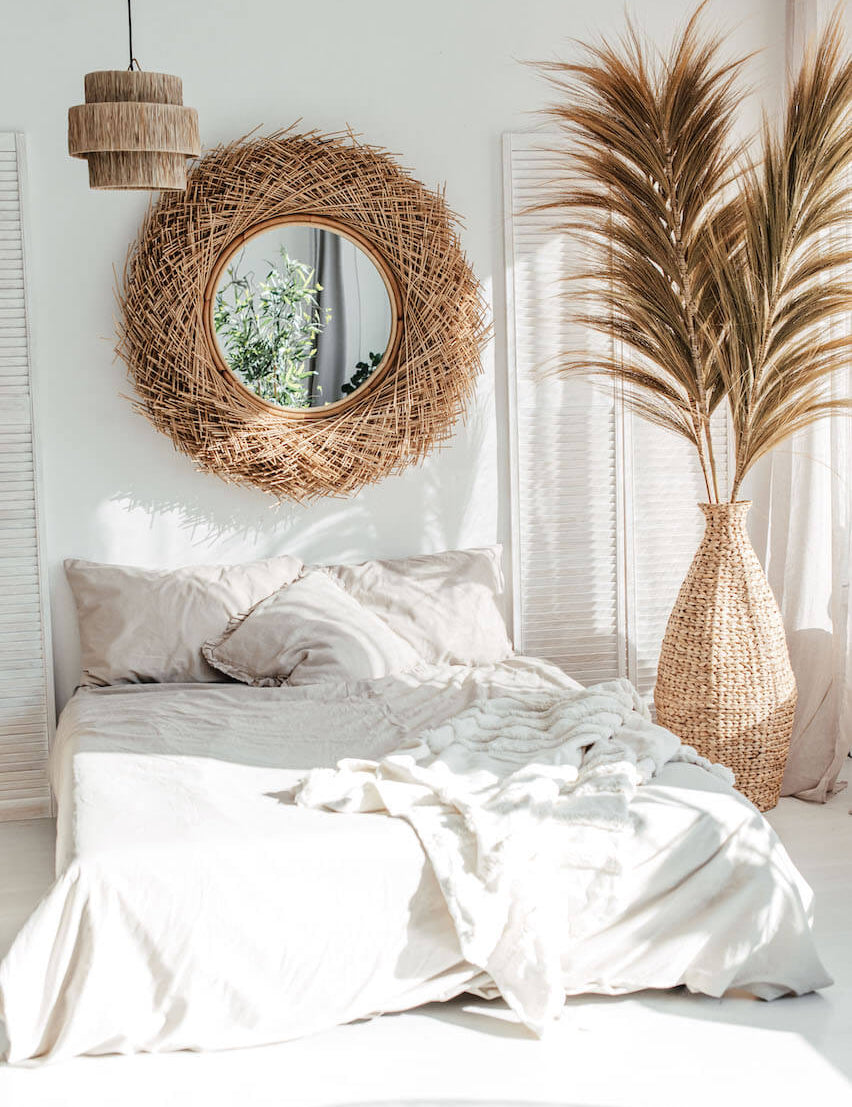 Nautical-themed room with a bed, decorative mirror, and potted plant.