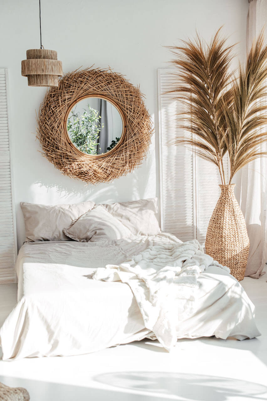 Nautical-themed room with a bed, decorative mirror, and potted plant.