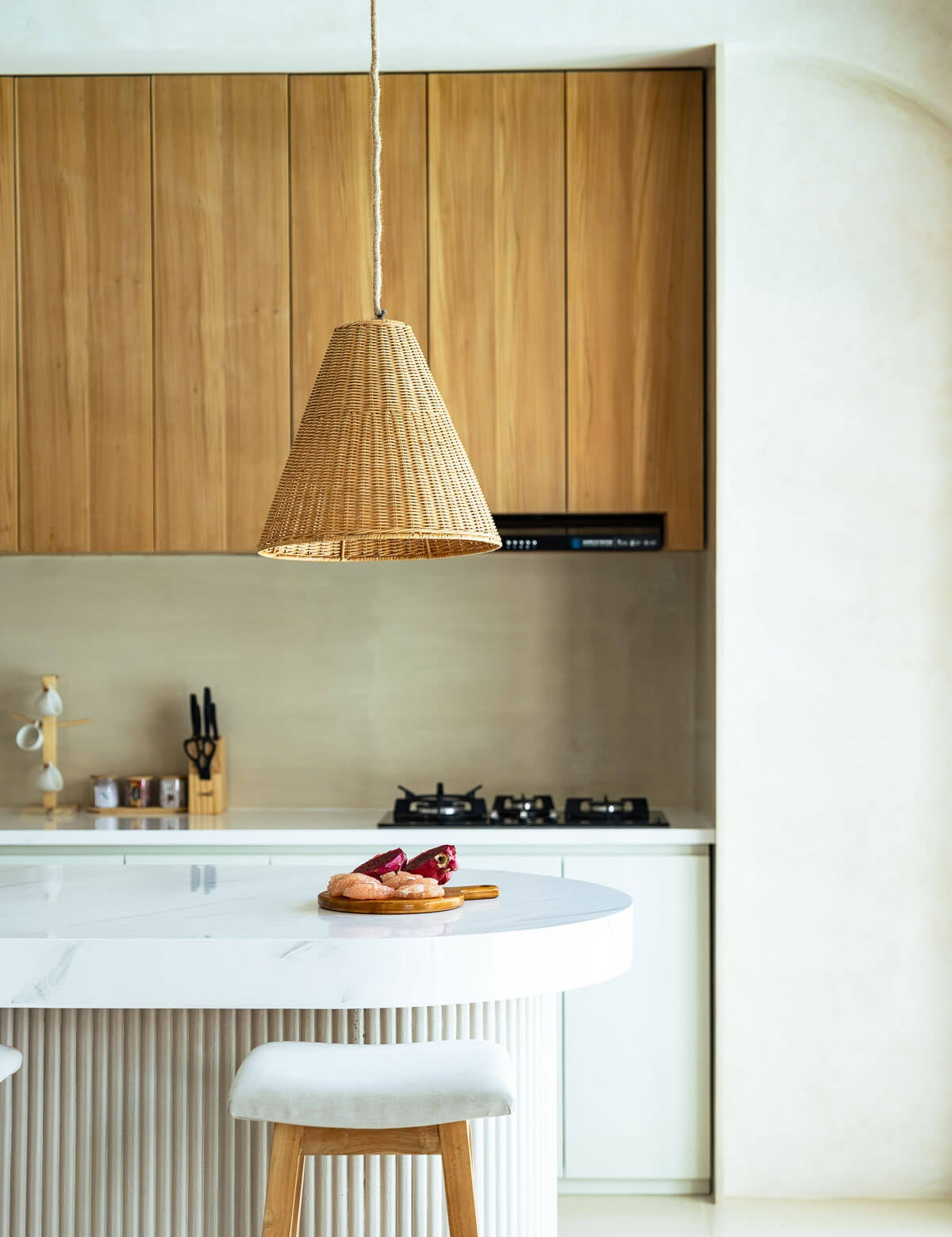 Modern kitchen with wooden cabinets, white countertop, and pendant light.